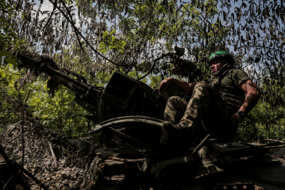 Un militar ucraniano observa la línea del frente desde su trinchera.