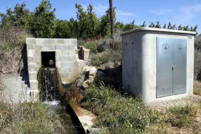 Una sèquia amb aigua i la caseta de bombament de la Junta de sequiatge de Lleida.