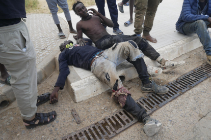 Dos de los migrantes que entraron en Melilla heridos y exhaustos. 