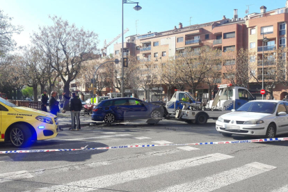 La grua retira el turisme contra el que ha impactat el cotxe que fugia de la Urbana.