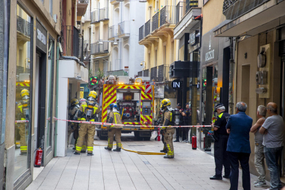 Bomberos y uno de los camiones ayer al mediodía en la calle Sant Antoni. 