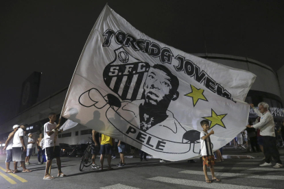 Aficionats del Santos a prop de l’estadi enarboren una gran bandera amb l’efígie de Pelé.