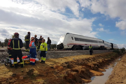 Equipos de rescate junto al tren descarrilado, donde se puede apreciar que la zona estaba anegada por las fuertes precipitaciones.