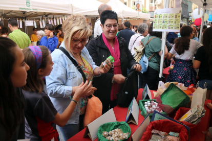 Dues dones comprant en una parada del Mercat del projecte Petits Empresaris de Ponent de Lleida
