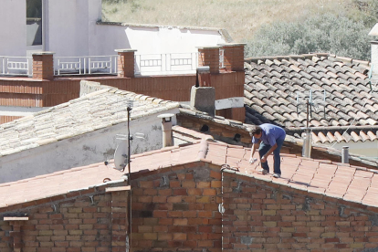 Camarasa. Vecinos y operarios municipales revisaban y reparaban ayer los tejados de las viviendas del municipio más afectadas por el temporal, con el fin de ganar seguridad y evitar accidentes