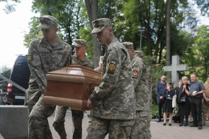 Soldados ucranianos cargan en Kyiv el féretro durante el funeral de un militar caído en combate. 