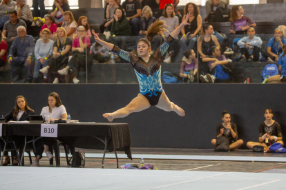 Una de las gimnastas realiza un salto mortal durante la competición disputada ayer en el pabellón Juanjo Garra de Lleida.