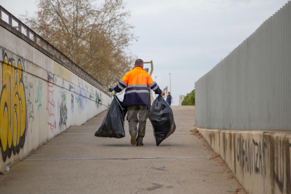 Retiren brossa a la canalització del riu Segre a Lleida després de la Festa Intercampus de la Universitat de Lleida