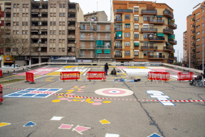 Vista general del mural que estan pintant al paviment de la plaça del Clot de les Granotes.