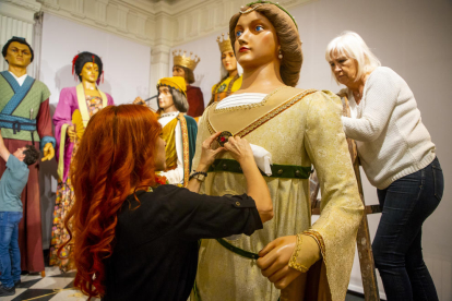 Cuatro peluqueros, con la ayuda de voluntarios de la ‘colla gegantera’, peinando ayer estas figuras. 