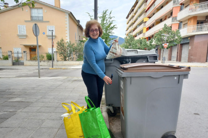 Una veïna obrint un contenidor amb codi.