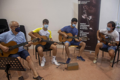 El professor de guitarra Xavier Gómez, ahir amb tres dels alumnes del curs de música de Cervera.