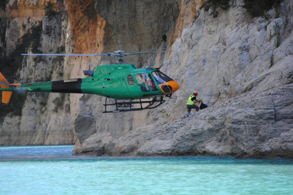 El helicóptero descendió hasta la orilla para dejar a uno de los operarios que trabajan en la ladera de Corcà.