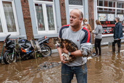 Un hombre sostiene un gato en la ciudad belga de Pepinster.