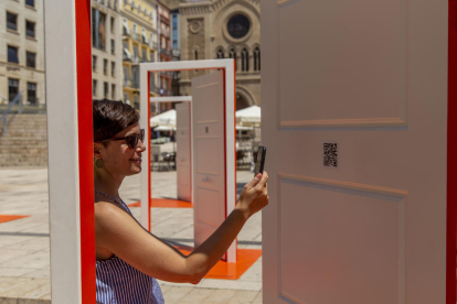 Una mujer fotografía el código QR de una de las puertas de la instalación ubicada en la plaza Sant Joan.