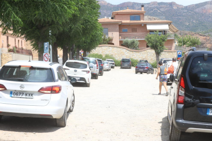 Un vigilant controla l’entrada de vehicles a la zona de la Platgeta de Camarasa i cobra cinc euros.