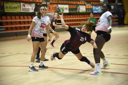 La jugadora del Lleida Handbol, Cati Casasola, lanza la pelota tras irse de dos jugadoras rivales.