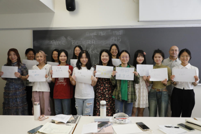 Trece de las catorce estudiantes chinas que han venido este año posan con unos carteles en chino hechos por ellas que dicen “¡Hola Lleida!” . 