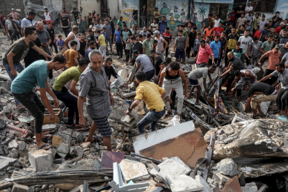 Palestins busquen supervivents entre la runa en un edifici derruït a la Franja de Gaza.