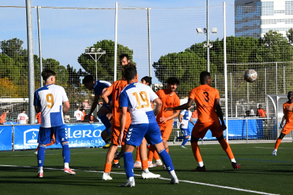 Jugadors de l’Atlètic Lleida ahir lluiten una pilota centrada a l’àrea.