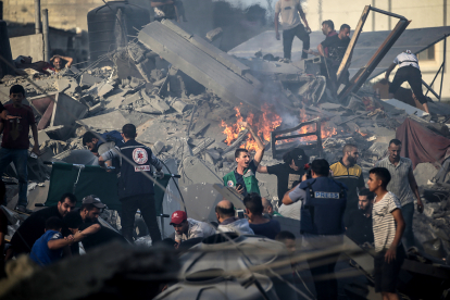 Sanitaris i equips de rescat palestins busquen supervivents entre la runa en Gaza.