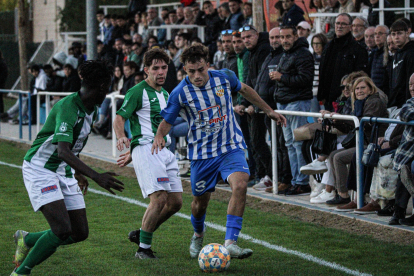 El jugador de l’Artesa Xavier Catalán, sent perseguit per dos futbolistes rivals.