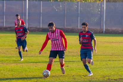 Un jugador del Puigvertenc condueix la pilota davant de la pressió del rival.