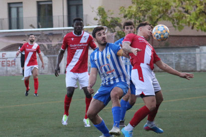 Un jugador local controla la pilota amb el pit, pressionat pel capità de l’Artesa de Lleida.
