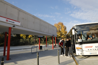 Diverses persones pujant ahir a un autobús en el primer dia de funcionament de l’estació de Juneda.