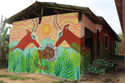 akkra. A la dreta, una dona observant una pintura de les dones africanes que va fer la Cristina a Akkra. A baix, un dels seus murals.