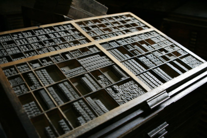 eines. Calaix de composició tipogràfica amb lletres de cos 48 (a sota). Taules per posar motllos per anar a màquines (esq.)