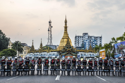 POLICIA ALS CARRERS. Agents de policia davant de la pagoda Sule, durant una manifestació contra el cop militar.