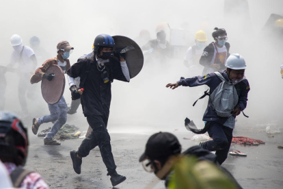 YANGON. Manifestants fugint dels gasos lacrimògens llançats per antidisturbis durant una protesta