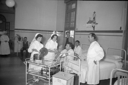 Joves infermeres fent cures a un malalt en un dels pavellons de l'hospital.