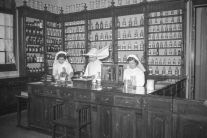 Dues infermeres treballant al servei de farmàcia juntament amb una monja de les Filles de la Caritat.