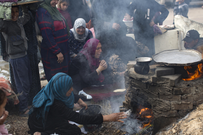 Famílies palestines desplaçades fan pa en un forn de llenya en un camp de refugiats a Rafah.