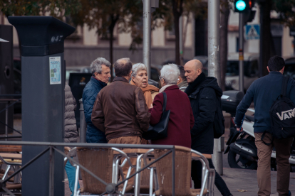 Un grup de persones en edat de poder estar cobrant una pensió conversen en un parc.