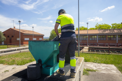 Un operari llançant carboni als filtres a l’estiu del 2022.