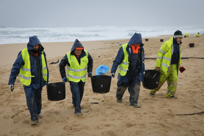 Operaris de neteja retiren els pèl·lets de plàstic en una platja d’O Vilar, a la Corunya.