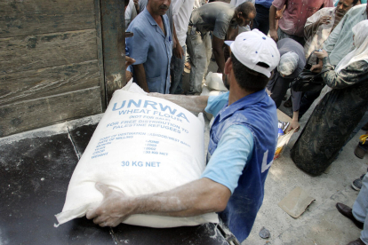 Un treballador de l’Agència de l’ONU per als Refugiats Palestins descarregant farina a Gaza.