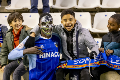 Musa celebra el triomf amb un nen i la seua màscara de Carnaval.