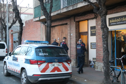 Agents dels Mossos d’Esquadra a la porta de l’edifici en el qual s’hauria comès el crim.