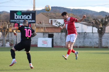 Un futbolista de l’Artesa de Segre remata una pilota de cap, davant del capità del San Juan.