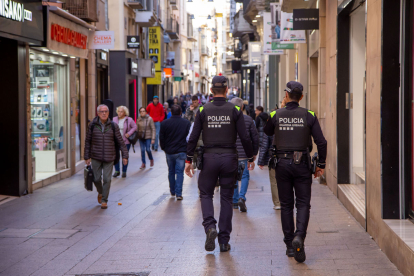 Dos agents de la Guàrdia Urbana patrullant per l’Eix Comercial.