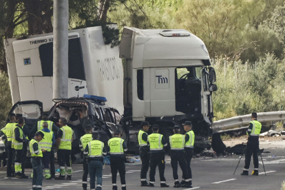 Guàrdies civils al lloc de l’accident, amb el camió que va atropellar diversos turismes, entre aquests un cotxe patrulla, encara creuat a la via.