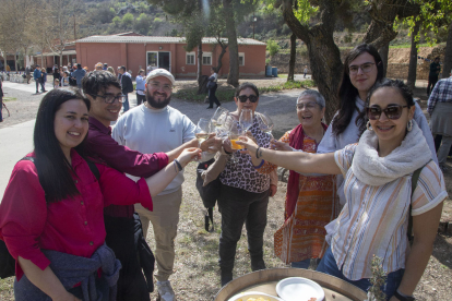 Alguns dels assistents al vermut fent un brindis (esquerra) i la presidenta de L’Olivera, Dolors Llonch, amb l’autor del mural (dreta).