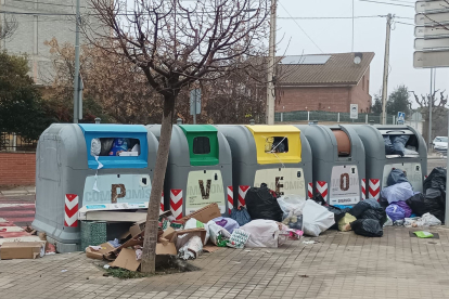 Els contenidors en un carrer de Rosselló desbordats per les escombraries.