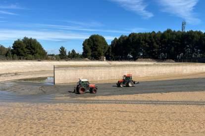 Dos tractors netegen el llot i els sediments que s’havien acumulat al fons dels dipòsits.