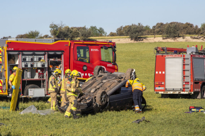 Els Bombers, ahir al costat del vehicle accidentat a Tàrrega.