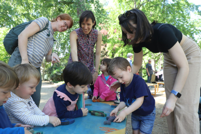 Un grup de nens juga amb els trencaclosques de Tocs de Fusta al Parc dels Somriures durant el matí.